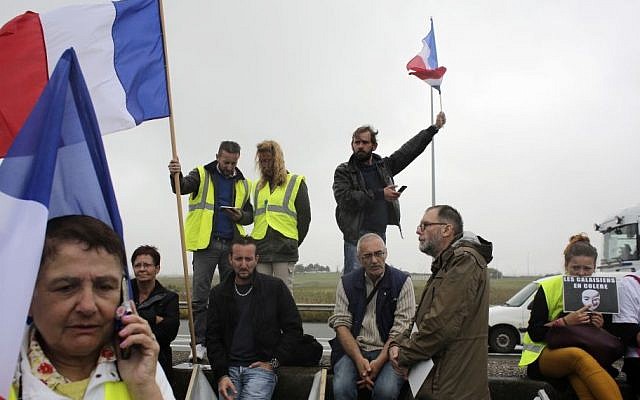 Demonstrators hold French flags as truckers block the highway near Calais, northern France, Monday Sept. 5, 2016. (AP/Thibault Camus)