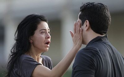 Jennifer Molleda looks at the blood specked face of her husband, Alan Wakim, who had two bullets whiz by his face after going through his windshield during a shooting along Wesleyan at Law Street that left multiple people injured and the alleged shooter dead, Monday morning, Sept. 26, 2016, in Houston. (Mark Mulligan/Houston Chronicle via AP)