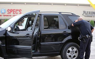 Police investigate a car that was shot during a shooting along Wesleyan at Law Street in Houston that left multiple people injured and the alleged shooter dead, Sunday morning, Sept. 25, 2016. (Mark Mulligan/Houston Chronicle via AP)