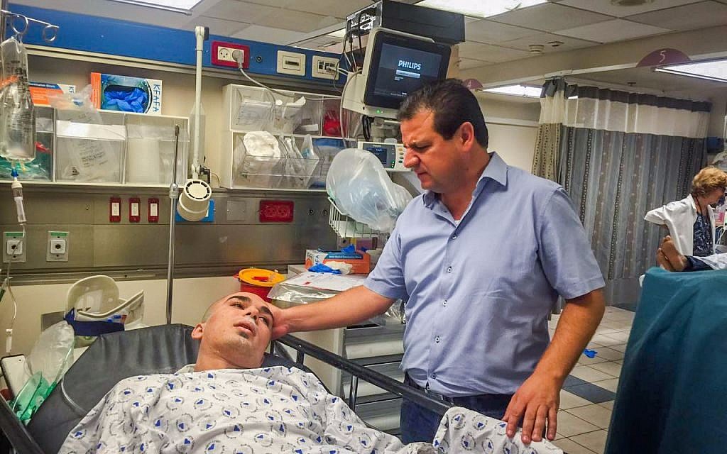 MK Ayman Odeh of the Joint Arab list visits a man wounded in a Tel Aviv building collapse, at the Ichilov Hospital on Monday, September 5, 2016 (Joint List)
