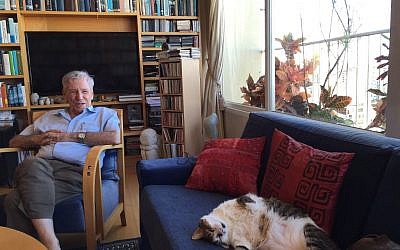 Amos Oz and his cat, in his Tel Aviv living room in September 2016 (Jessica Steinberg/Times of Israel)