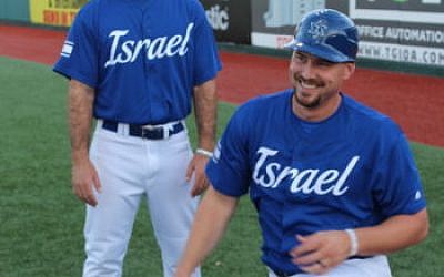 Team Israel catcher Ryan Lavarnway enjoys a moment in pregame warmups with bullpen coach Alon Leichman in Brooklyn, Sept. 22, 2016. Lavarnway delivered three hits in Israel’s victory over Great Britain. (Hillel Kuttler via JTA)
