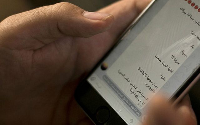 In this May 22, 2016 file photo, an activist looks at an Islamic State group marketplace on the encrypted app Telegram, advertising a 12-year-old Yazidi girl as a slave for the price of $12,500, in a photo taken in northern Iraq. "Peace be upon you and the mercy and blessings of God," the text reads in Arabic. "There is a female slave - Virgin - Beautiful - 12 years old - Her Arabic is weak - Clean - Her price has reached $12,500, and she will be sold soon. The photo is private. Only those who have the money may request the picture." (AP Photo/Maya Alleruzzo, File)