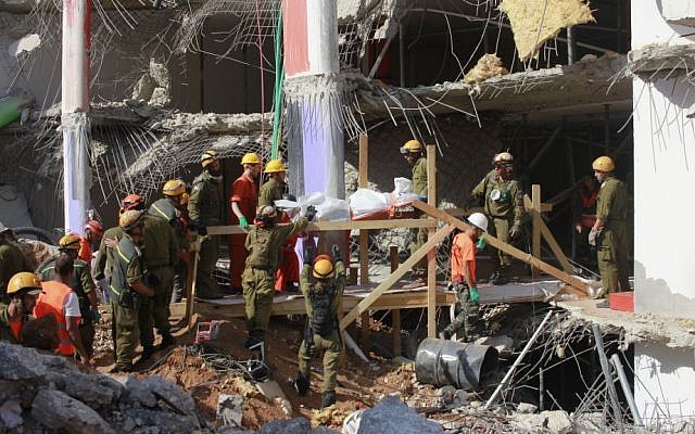 Search and rescue workers remove a third body from the rubble of a collapsed parking garage in Tel Aviv on September 6, 2016. (Judah Ari Gross/Times of Israel)