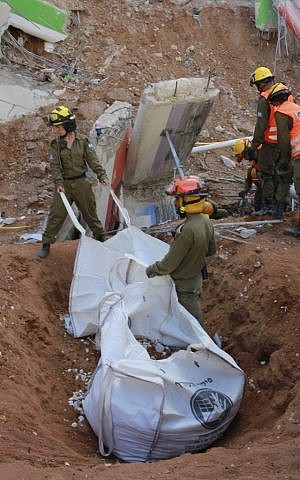 Soldiers in the IDF Home Front Command fill bags with rubble during the rescue effort at a collapsed parking garage in Tel Aviv's Ramat Hahayal neighborhood on September 6, 2016. (Judah Ari Gross/Times of Israel)