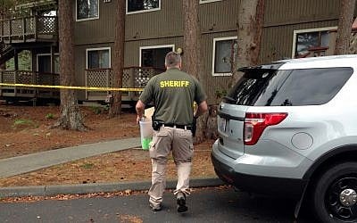 Investigators are seen at the apartment complex that has been tied to Arcan Cetin, the alleged Cascade Mall shooter, in Oak Harbor, Washington, September 25, 2016. Authorities carried boxes from a rear, upstairs apartment in the four-unit building. (AP Photo/Martha Bellisle)