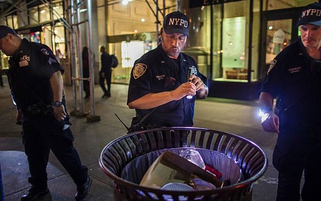 Police officers look for suspicious packages along Fifth Avenue near the scene of an explosion on West 23rd Street and 6th Avenue in Manhattan's Chelsea neighborhood, in New York, early Sunday, Sept. 18, 2016. (AP Photo/Andres Kudacki)