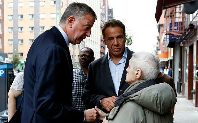 New York Mayor Bill de Blasio, left, and New York Gov. Andrew Cuomo talk with area residents Sunday, Sept. 18, 2016, while touring the site of an explosion that occurred on Saturday night in the Chelsea neighborhood of New York. (Justin Lane/EPA via AP, Pool)