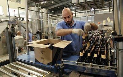 Yazan Karadsheh, right, founder of the Carakale Brewery in Fuheis, Jordan, talks to a technician while head brewer Jordan Wombeke quality tastes beer off the assembly line, September 6, 2016 (AP Photo/Sam McNeil)