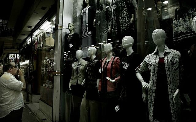 In this Wednesday, Aug. 9, 2016 file photo, a man looks at a women's boutique with discounted prices attached to the clothes in downtown Cairo, Egypt. (AP Photo/Nariman El-Mofty, File)