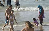 In this Friday, Sept. 2, 2016 photo, a Muslim woman holds her child at a beach in Tel Aviv, Israel. (AP Photo/Ariel Schalit)