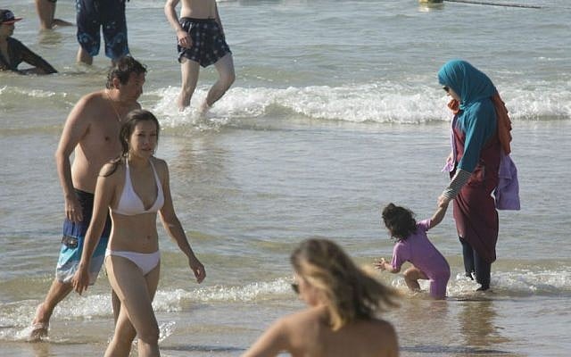 In this Friday, Sept. 2, 2016 photo, a Muslim woman holds her child at a beach in Tel Aviv, Israel. (AP Photo/Ariel Schalit) In this Friday, Sept. 2, 2016 photo, a Muslim woman holds her child at a beach in Tel Aviv, Israel. (AP Photo/Ariel Schalit)