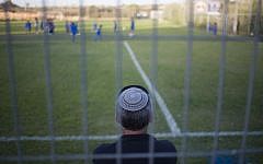 A man watches his son during a training session of the Beitar Shabi Givat Zeev soccer club, in the West Bank Jewish settlement of Givat Ze'ev, near Jerusalem, Thursday, Sept. 22, 2016. (AP Photo/Ariel Schalit)