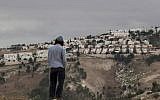 In this Dec. 5, 2012 file photo, a Jewish settler looks at the West Bank settlement of Maaleh Adumim, from the E-1 area on the eastern outskirts of Jerusalem.  (AP Photo/Sebastian Scheiner, File)