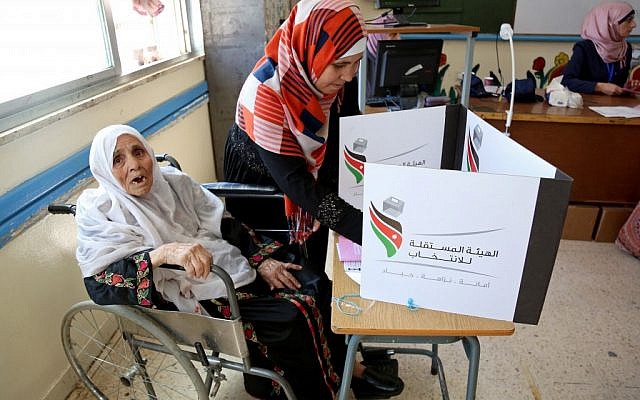 A woman is assisted as she votes at a polling station in Amman, Jordan, Tuesday, Sept. 20, 2016. (AP Photo/Raad Adayleh)
