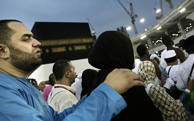A man holds his wife as they circle the Kaaba, Islam's holiest shrine, at the Grand Mosque in the Muslim holy city of Mecca, Saudi Arabia, Thursday, Sept. 8, 2016. (AP Photo/Nariman El-Mofty)