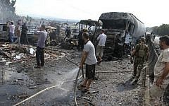 In this photo released by the Syrian official news agency SANA, Syrian security forces, emergency services and residents look at the remains of burned vehicles at the site of a bombing in Tartus, Syria, Monday, Sept. 5, 2016. (SANA via AP)
