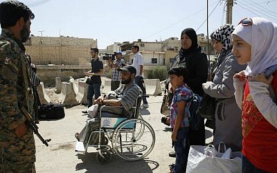 Syrians wait to board buses as they leave the Moadamiyeh suburb of Damascus, Syria, on Friday, Sept. 2, 2016. (AP Photo)