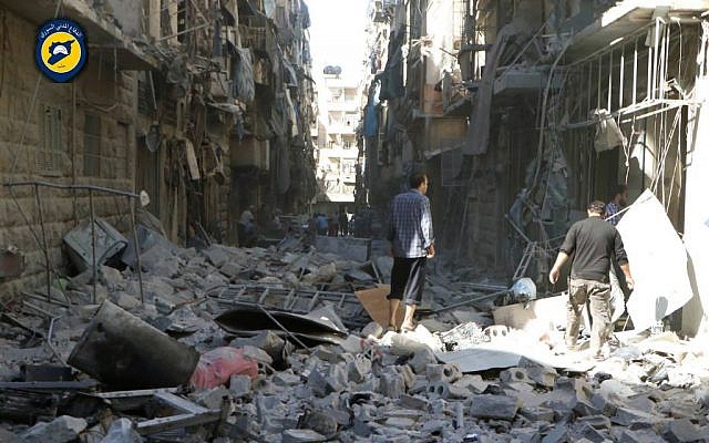Syrians inspect damaged buildings after airstrikes hit in Aleppo, Syria, September 24, 2016. (Syrian Civil Defense White Helmets via AP)