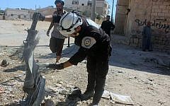 In this photo, members of the Syrian Civil Defense group, known as the White Helmets, inspect cluster bombs in the Khan Sheikhoun neighborhood of Idlib, Syria, September 29, 2016. (Syrian Civil Defense White Helmets via AP)