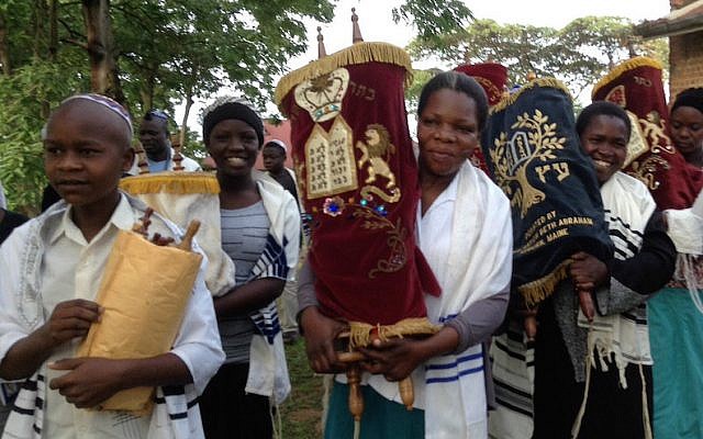 Illustrative: As part of a B'chol Lashon initiative, in anticipation of the construction of a new synagogue in Nabagoye, Uganda, the women and children there were given the honor of transferring the Torahs from the old synagogue to a temporary home. (Courtesy of Be’chol Lashon via JTA)