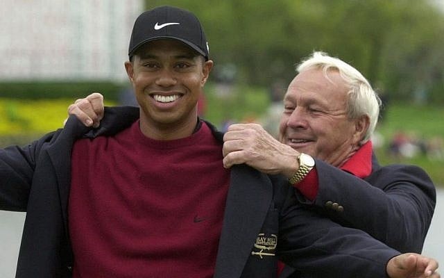 Tiger Woods, left, being helped into his jacket for winning the Bay Hill Invitational by tournament host Arnold Palmer in Orlando, Fla, March 18, 2001. (AP/Scott Audette, File)
