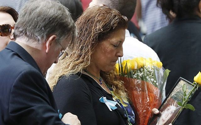 A mourner holds a photo of her loved one during the 15th anniversary of the attacks of the World Trade Center at the National September 11 Memorial, Sunday, Sept. 11, 2016, in New York. (AP/Mary Altaffer)