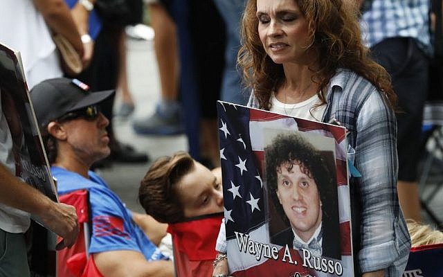 A mourner holds a photo of her loved one during the 15th anniversary of the attacks of the World Trade Center at the National September 11 Memorial, Sunday, Sept. 11, 2016, in New York. (AP/Mary Altaffer)
