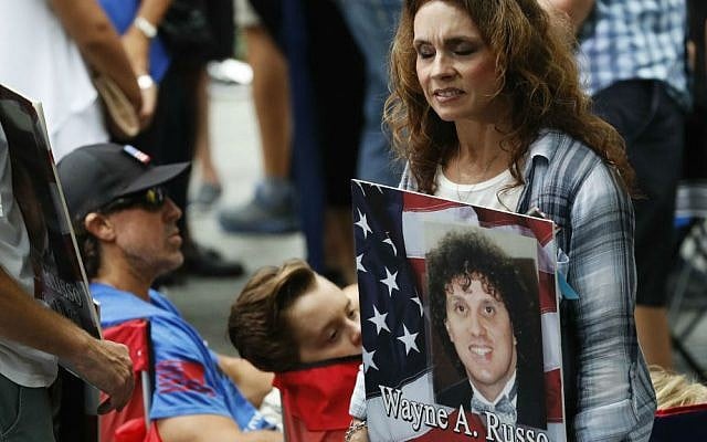 A mourner holds a photo of her loved one during the 15th anniversary of the attacks on the World Trade Center at the National September 11 Memorial, Sunday, Sept. 11, 2016, in New York. (AP Photo/Mary Altaffer)