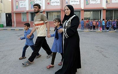 In this Thursday, Sept. 1, 2016 photo, a Syrian refugee family brings their children to school in Amman, Jordan. (AP Photo/Ahmad Alameen)