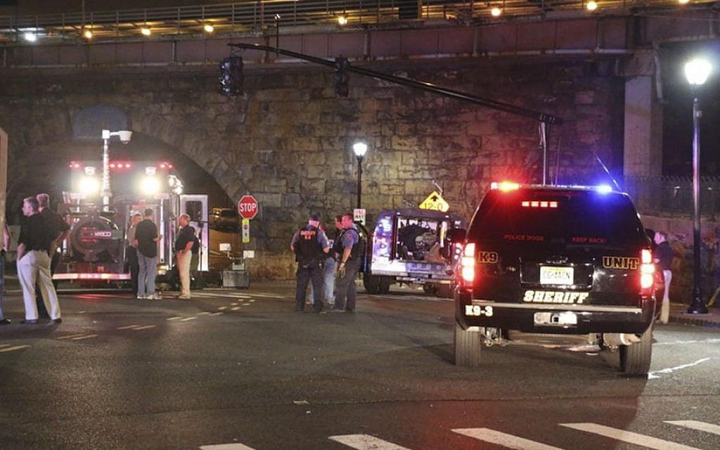 Bomb squad personnel stand around the scene of an explosion near the train station, early Monday, Sept 19, 2016, in Elizabeth, NJ (Jessica Remo/NJ Advance Media via AP)