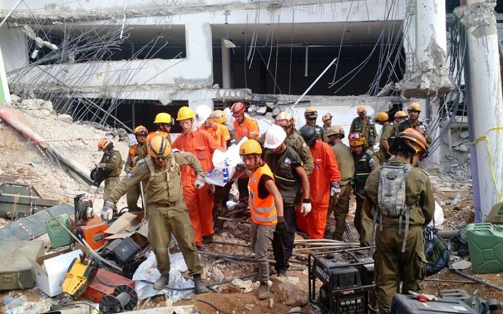 Search and rescue workers remove a third body from the rubble of a collapsed parking garage in Tel Aviv on September 6, 2016. (Judah Ari Gross/Times of Israel)
