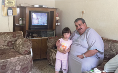 The patriarch of the Kirresh  family , Mazen,  sitting with his granddaughter in their home. The Kirresh family was evicted September 15th by Israeli authorities after losing a battle in Israeli courts to remain tenants.  (courtesy OCHA)