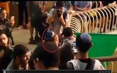Lehava leader Bentzi Gopstein (circled in red) arguing with a police officer at a choir performance in Jerusalem on September 22 2016. (screen capture: Channel 10)