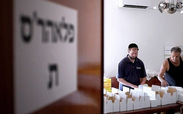 Shloime Lappe from London (L) and Angelo Cava prepare shipments of lime-green citron fruits in Santa Maria Del Cedro, southern Italy, on September 14, 2016. (AFP PHOTO / ALBERTO PIZZOLI)