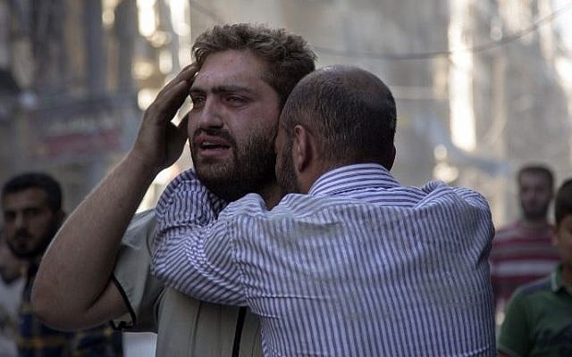 Syrians react as the bodies of children are pulled from the rubble of a building following government forces air strikes in the rebel held neighborhood of Al-Shaar in Aleppo on September 27, 2016. (AFP PHOTO / KARAM AL-MASRI)
