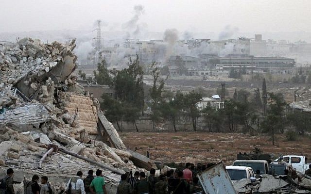 Syrian regime forces gather at the Kindi Hospital as smoke billows following airstrikes on Aleppo on October 2, 2016. (AFP PHOTO / GEORGE OURFALIAN)
