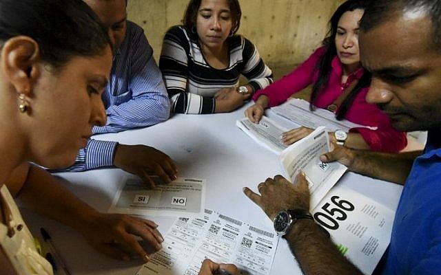 Electoral officials count votes at a polling station after a referendum on whether to ratify a historic peace accord to end Colombia's 52-year war between the state and the communist FARC rebels, in Cali, Colombia, on October 2, 2016. (AFP PHOTO / LUIS ROBAYO) Electoral officials count votes at a polling station after a referendum on whether to ratify a historic peace accord to end Colombia's 52-year war between the state and the communist FARC rebels, in Cali, Colombia, on October 2, 2016. (AFP PHOTO / LUIS ROBAYO)