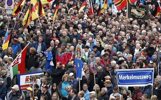 Supporters of Pegida (Patriotic Europeans Against the Islamization of the Occident) take part in a protest against German Chancellor Angela Merkel and her policy on October 3, 2016 in Dresden, eastern Germany (AFP PHOTO / Odd ANDERSEN) Supporters of Pegida (Patriotic Europeans Against the Islamization of the Occident) take part in a protest against German Chancellor Angela Merkel and her policy on October 3, 2016 in Dresden, eastern Germany (AFP PHOTO / Odd ANDERSEN)