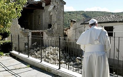 Pope Francis prays in front of damaged houses during his visit to the Italian hamlet of Accumoli on October 4, 2016, after an earthquake hit the area on August 24, claiming nearly 300 lives.  (AFP PHOTO/TIZIANA FABI)