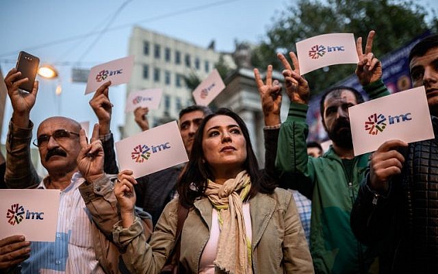 Employees and supporters of pro-Kurdish television channel IMC TV and supporters of other media previously closed by authorities hold signs bear the IMC logo during a demonstration in Istanbul on October 4, 2016. (AFP/Ozan Kose) Employees and supporters of pro-Kurdish television channel IMC TV and supporters of other media previously closed by authorities hold signs bear the IMC logo during a demonstration in Istanbul on October 4, 2016. (AFP/Ozan Kose)