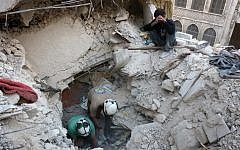 Syrian civil defence volunteers, known as the White Helmets, search for victims amid the rubble of destroyed buildings following a government forces air strike on the rebel-held neighbourhood of Bustan al-Basha in the northern city of Aleppo, on October 4, 2016. (AFP/Thaer Mohammed)