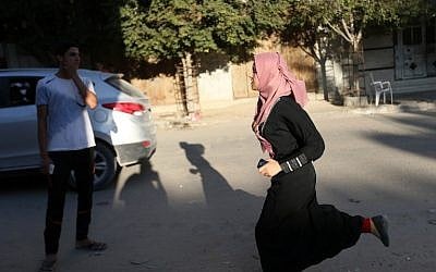 A Palestinian girl runs out of her home in Gaza City's eastern Shejaiya neighborhood following an Israeli military strike on October 5, 2016. (Mohammed Abed/AFP)