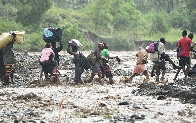 Haitian people cross the river La Digue in Petit Goave where the bridge collapsed during the rains of the Hurricane Matthew, southwest of Port-au-Prince, October 5, 2016. (AFP PHOTO / HECTOR RETAMAL) Haitian people cross the river La Digue in Petit Goave where the bridge collapsed during the rains of the Hurricane Matthew, southwest of Port-au-Prince, October 5, 2016. (AFP PHOTO / HECTOR RETAMAL)