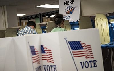 Joseph and Maria Caruso vote inside the Early Vote Center in downtown Minneapolis, Minnesota after work on October 5, 2016. (AFP PHOTO / STEPHEN MATUREN)