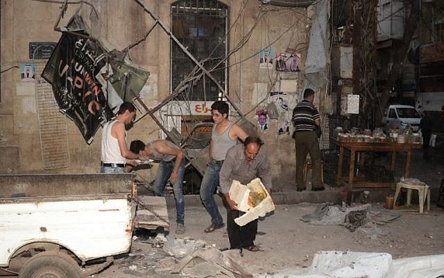 Syrians inspect the damage caused by an artillery attack in the al-Jamiliyeh neighborhood in the government-controlled side of the northern city of Aleppo following fighting between regime forces and rebels, on October 6, 2016. (AFP PHOTO / GEORGES OURFALIAN)