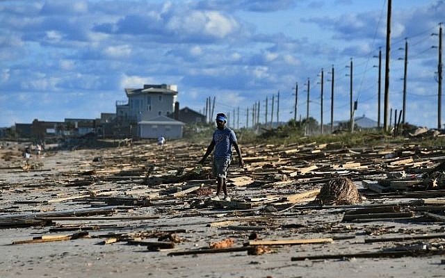 A man walks on a debris covered beach in St Augustine, Florida, on October 8, 2016, after Hurricane Matthew passed the area. (AFP PHOTO / Jewel SAMAD)