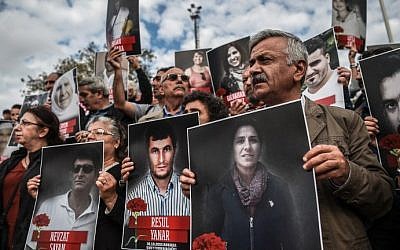 People shout slogans and hold up poster pictures of victims killed in the October 10, 2015 blasts in Ankara as they mark the first year anniversary of the attacks during a demonstration on October 9, 2016 in Istanbul's Kadikoy district. (AFP Photo/Ozan Kose)