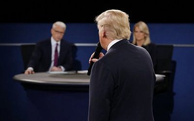 Moderators Anderson Cooper of CNN (L) and Martha Raddatz of ABC listen as Republican presidential nominee Donald Trump speaks during the second debate at Washington University in St. Louis, Missouri on October 9, 2016. (AFP PHOTO / POOL / JIM BOURG)