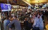 Patrons in a bar watch the second presidential debate between US Democratic presidential candidate Hillary Clinton and US Republican presidential candidate Donald Trump near Times Square in New York on October 9, 2016. (AFP/KENA BETANCUR)